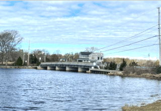 The Old Providence Road Bridge in Swansea, also known as the Myles Bridge and Bridge MH-11, crosses the Palmer River and is in a low-lying area with known flooding issues.